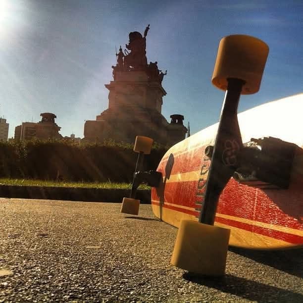Board Hussein com listras vermelhas — Monumento à Independência ao fundo