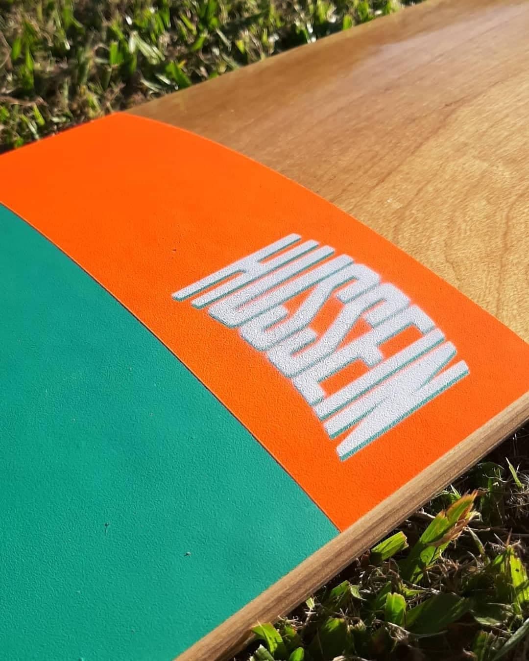 Hussein deck on grass — orange graphic