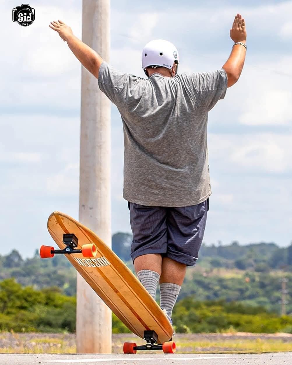 Skatista com capacete descendo ladeira